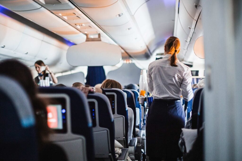 Passengers and flight attendant inside airplane