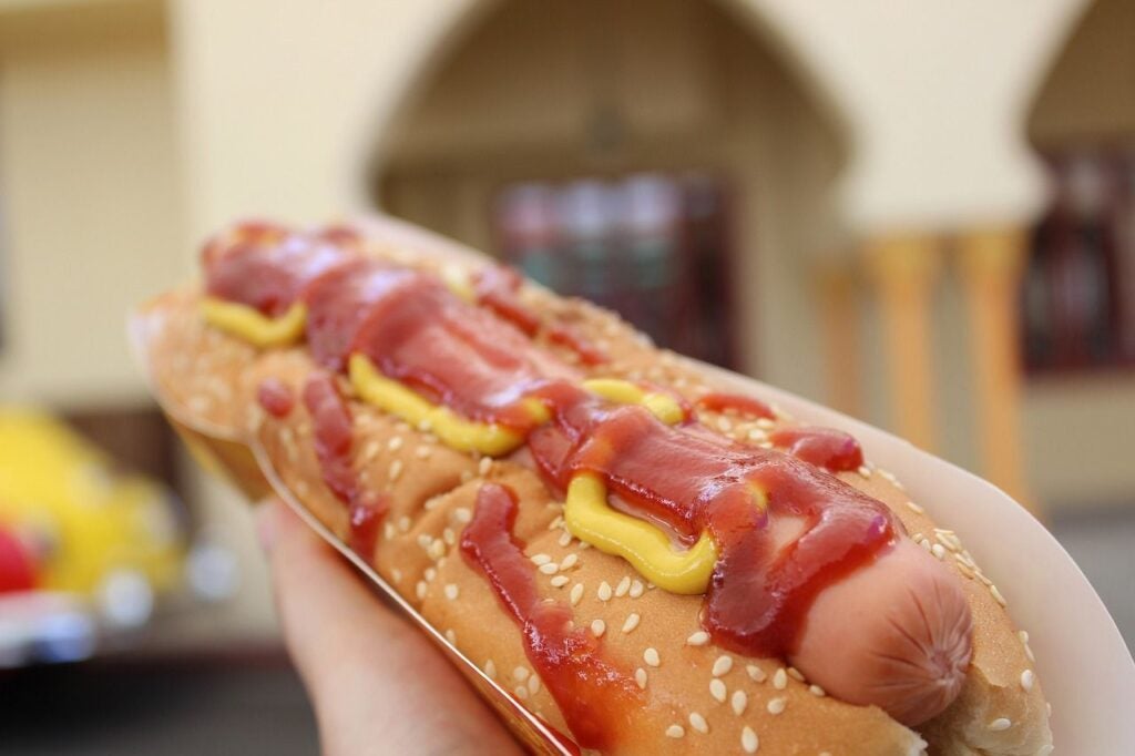 Hot dog in a bun with ketchup and mustard.