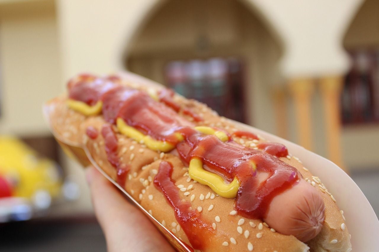 Hot dog in a bun with ketchup and mustard.
