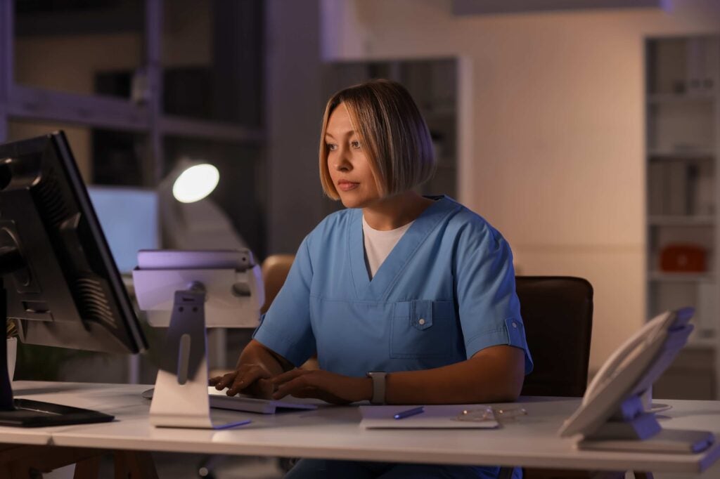 Woman appears to be working in a lab or hospital at night.