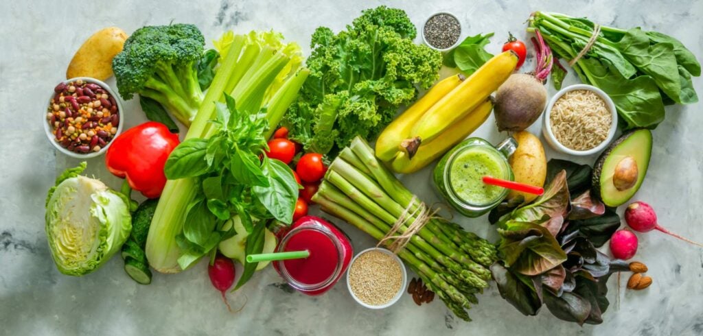 Overhead photo of produce (leafy greens bananas, etc) for alkaline diet entry.
