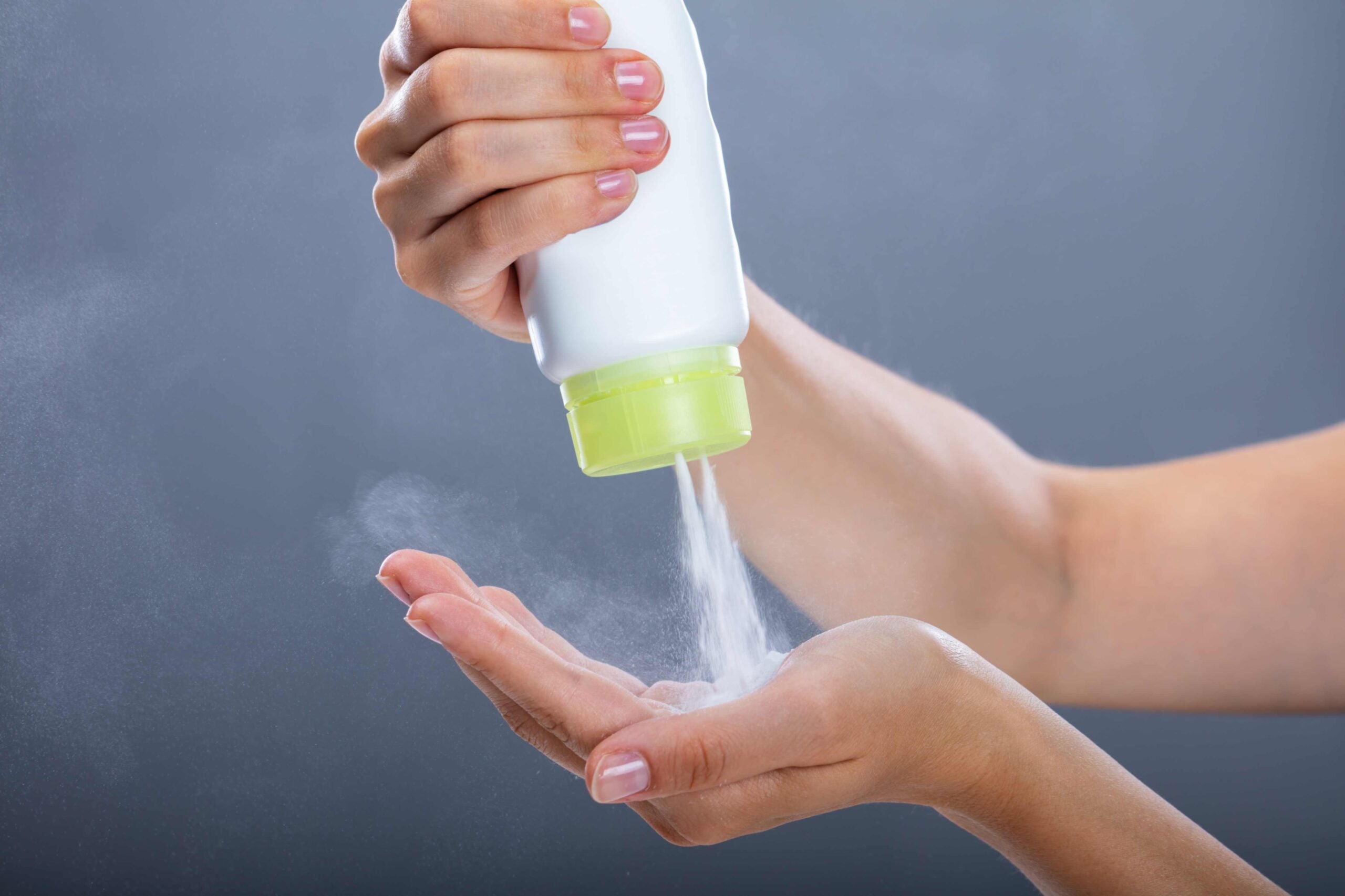 Hand pouring talcum powder on palm