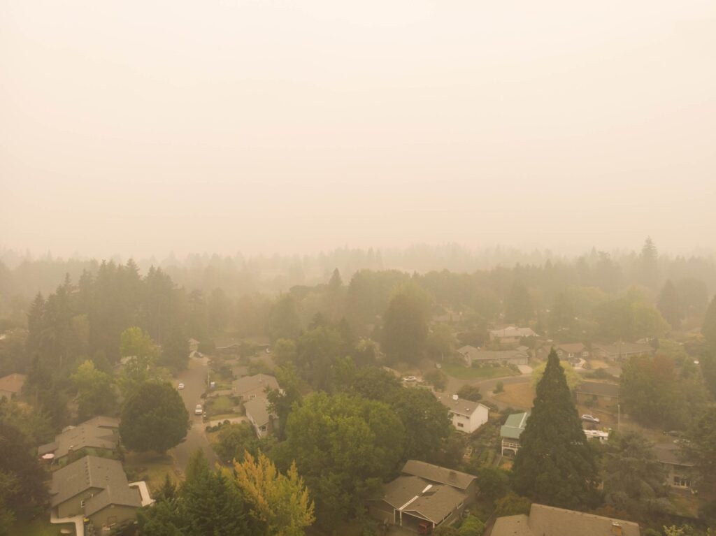 Overhead view of a neighborhood with wildfire smoke making it hazy