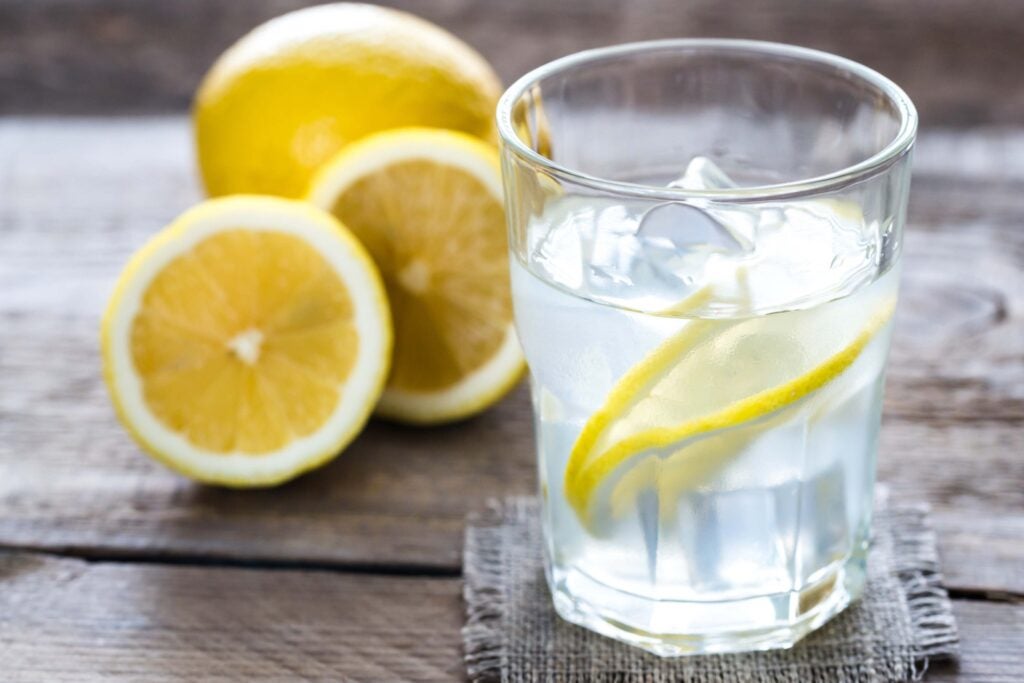 Lemons next to water with lemon slices