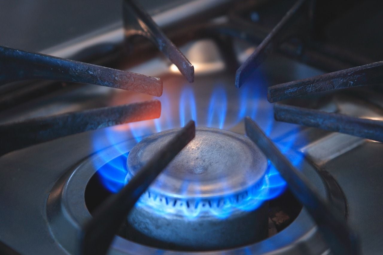 Close-up photo of a burner on a gas stove that is lit.