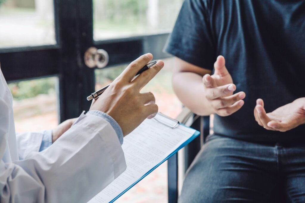Set of hands that are clearly a doctor (white coat) talking to a patient.